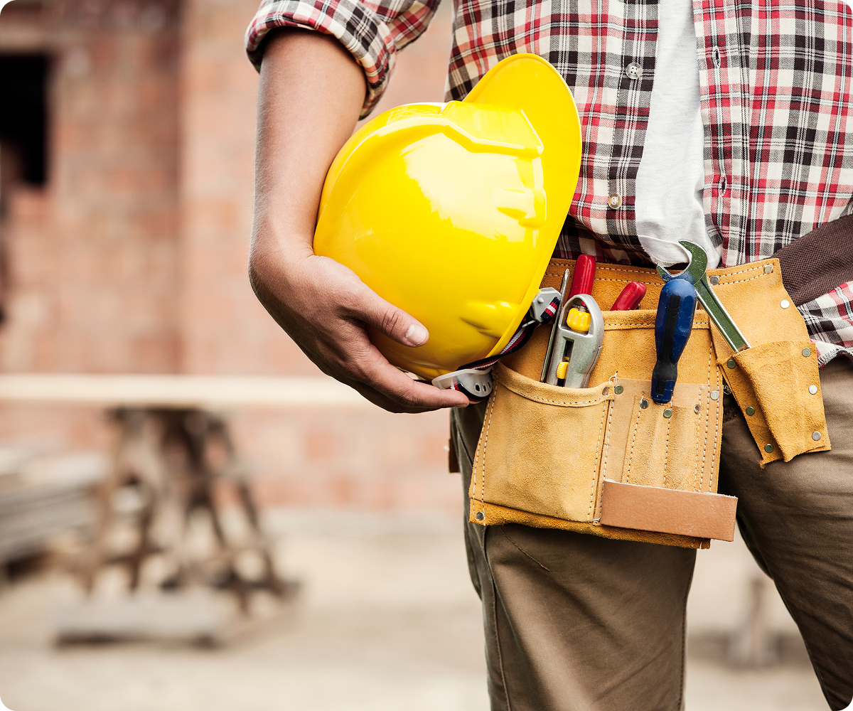 Homme en habit de travail tenant un casque de chantier